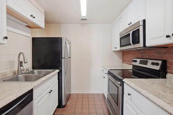 a kitchen with stainless steel appliances granite countertop a sink stove and microwave