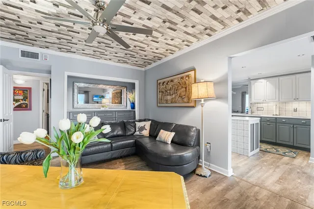 a living room with furniture flowerpot and a chandelier