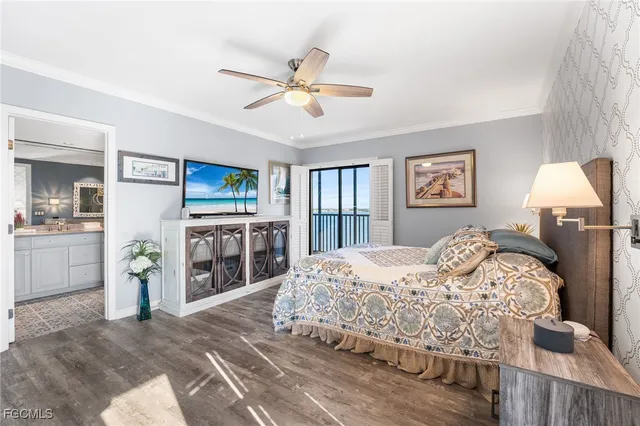 a bedroom with a large bed a chandelier and dresser