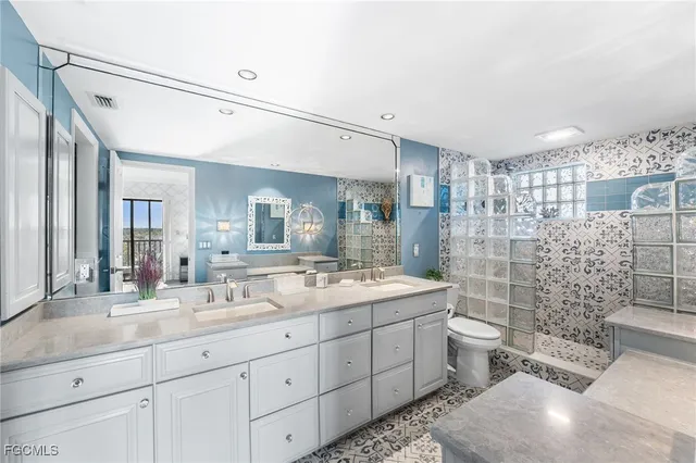 a spacious bathroom with a double vanity sink toilet and shower