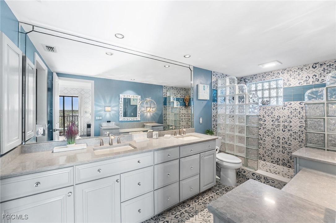 1910 Virginia Avenue, Unit 803 Fort Myers, FL 33901 - Photo 37 of 48 a spacious bathroom with a double vanity sink toilet and shower