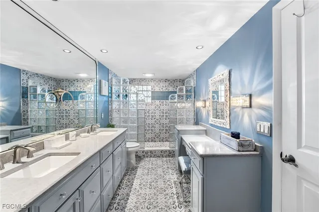 a bathroom with a double vanity sink and mirror with shower