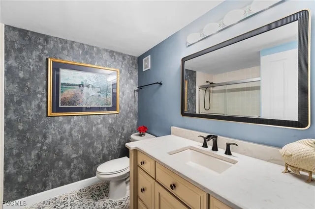 a bathroom with a toilet a sink and mirror