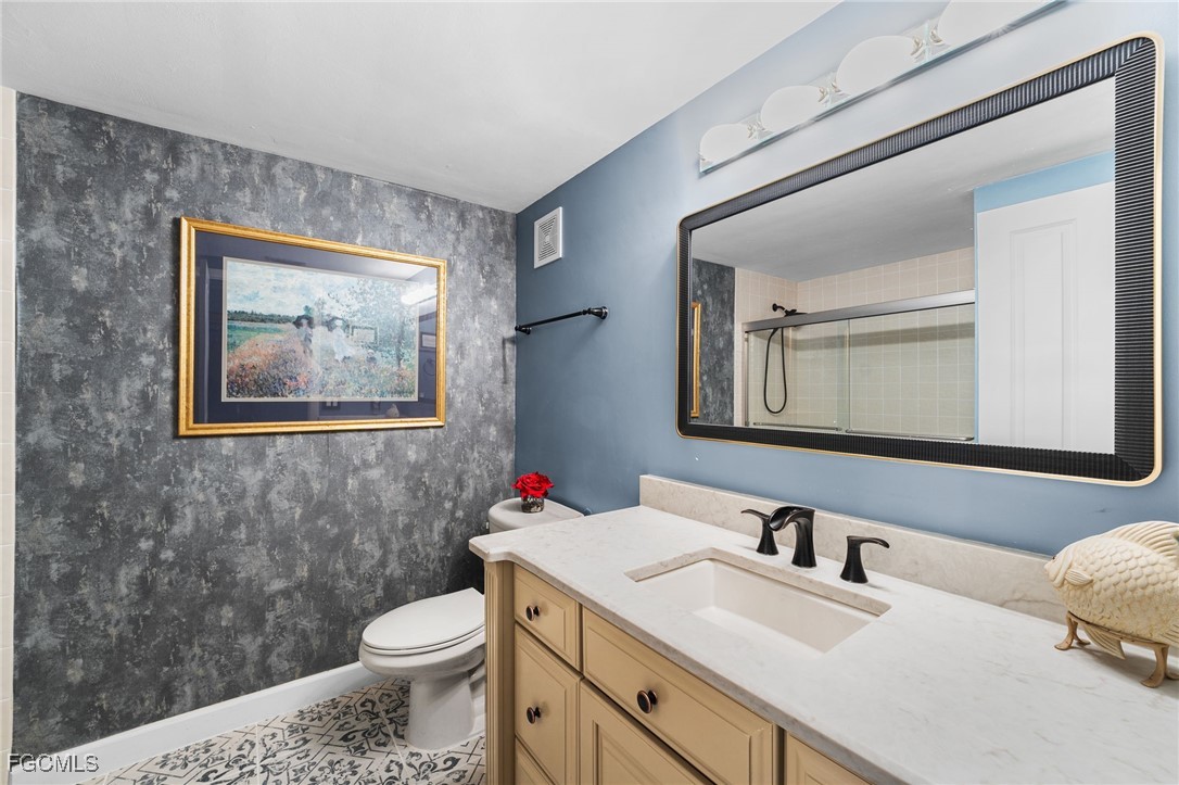 1910 Virginia Avenue, Unit 803 Fort Myers, FL 33901 - Photo 42 of 48 a bathroom with a toilet a sink and mirror