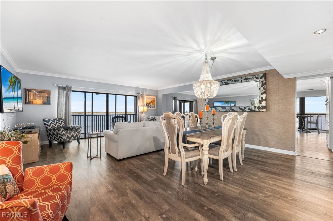 1910 Virginia Avenue, Unit 803 Fort Myers, FL 33901 - Photo 6 of 48 a dining room with wooden floor a chandelier a glass table and chairs