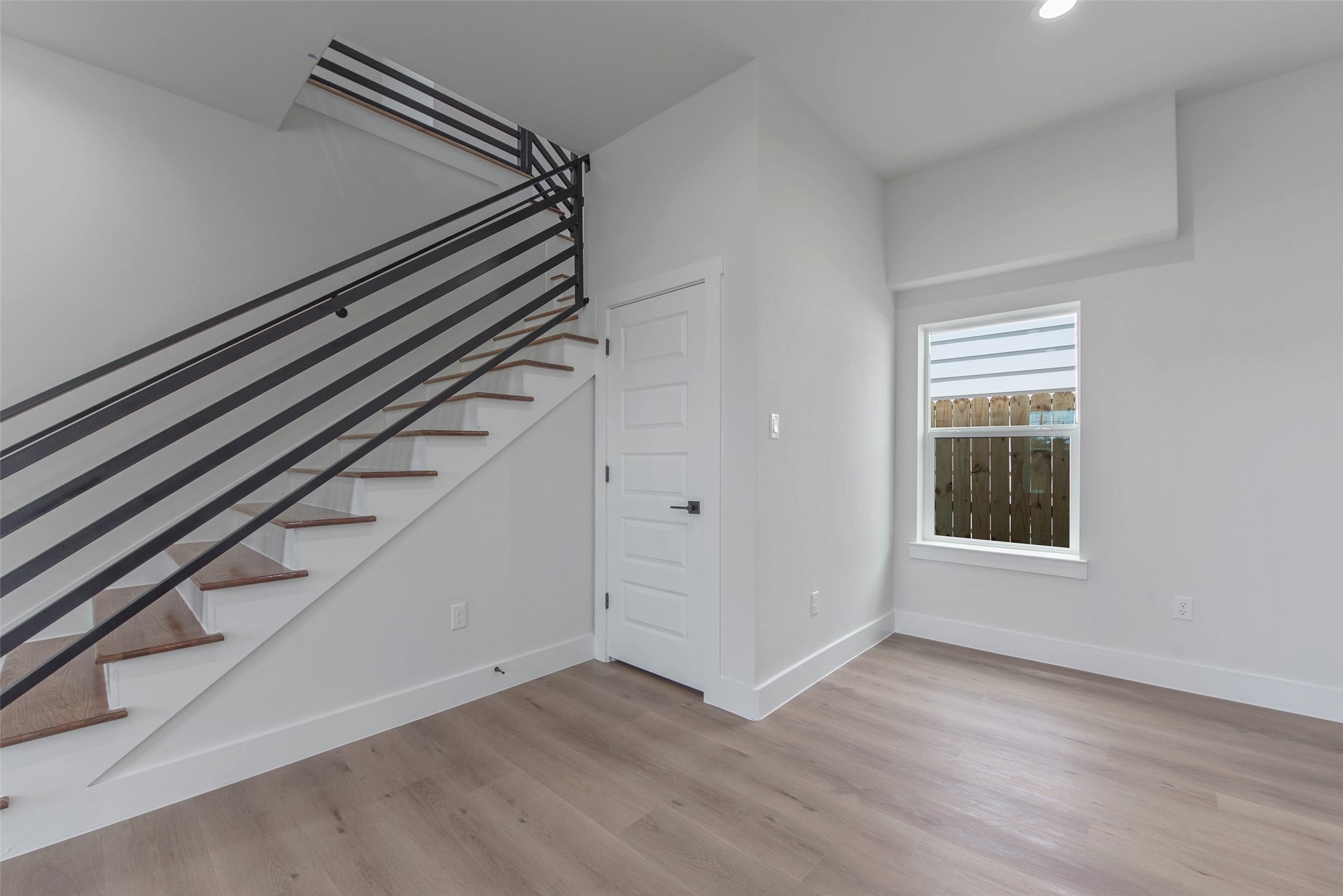 9311 Jutland Road Houston, TX 77033 - Photo 9 of 28 Wrought iron-accented stairs lead you to an inviting upstairs flex space, offering versatility, space, and style.