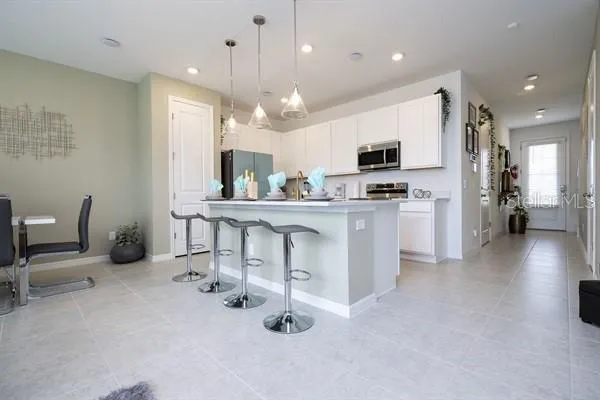 a kitchen with kitchen island granite countertop a sink cabinets and stainless steel appliances