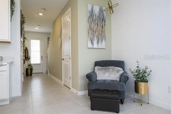 a spacious bedroom with a bed and a flat tv screen on dresser