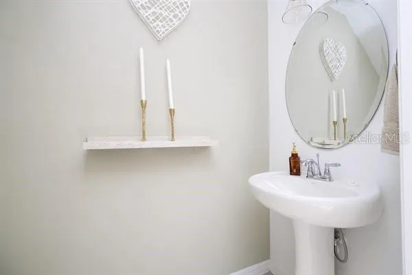 a white bed sitting in a bedroom next to a lamp
