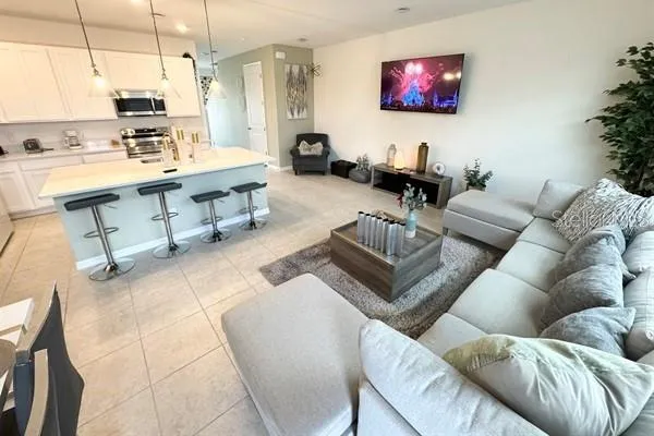 a living room with furniture a rug and a large window