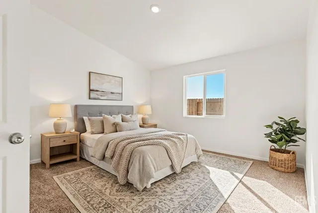 a bedroom with a large bed and a potted plant
