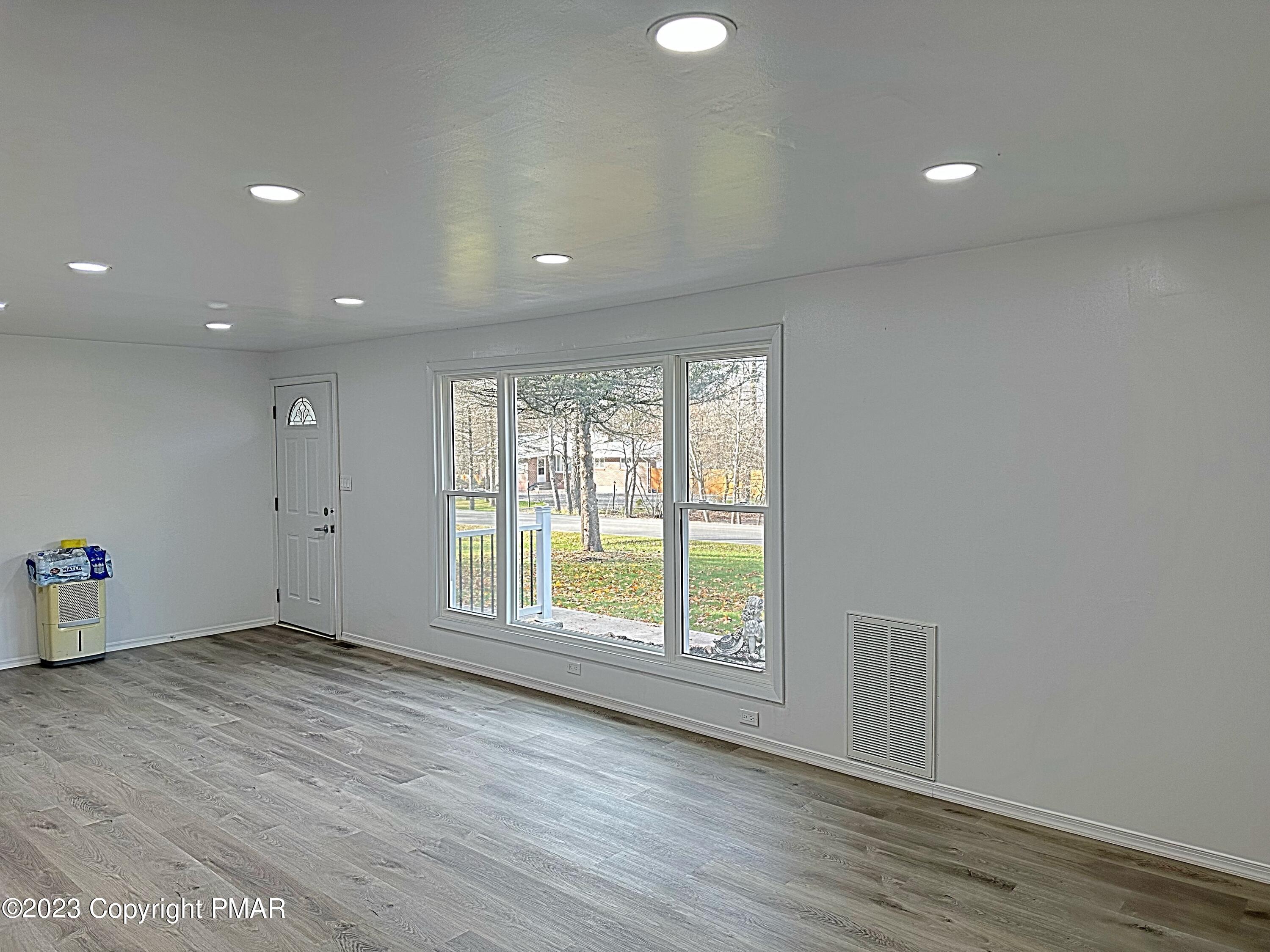 350 Mountain Road Albrightsville, PA 18210 - Photo 2 of 23 an empty room with wooden floor and windows