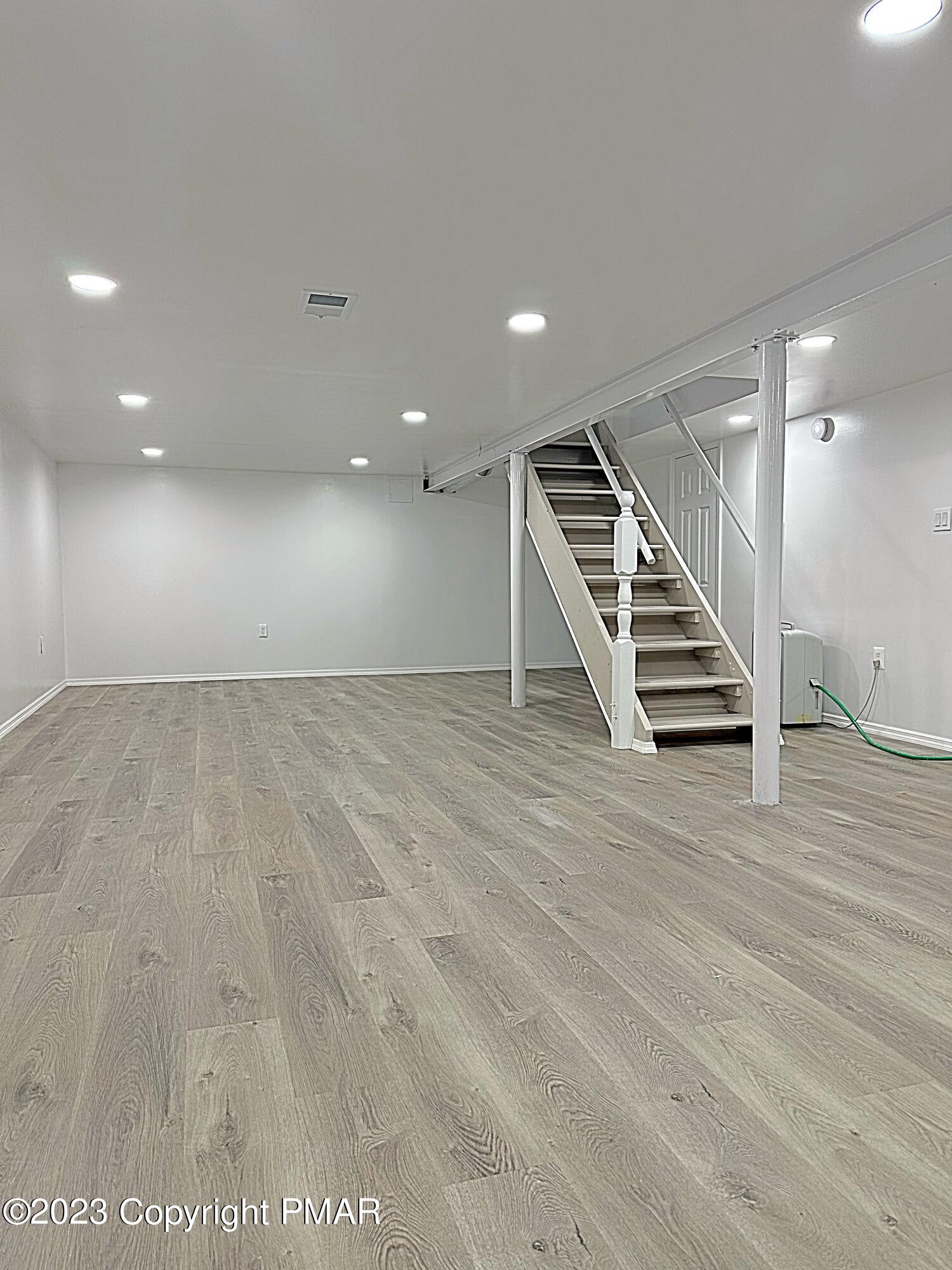 350 Mountain Road Albrightsville, PA 18210 - Photo 10 of 23 an empty room with wooden floor and stairs