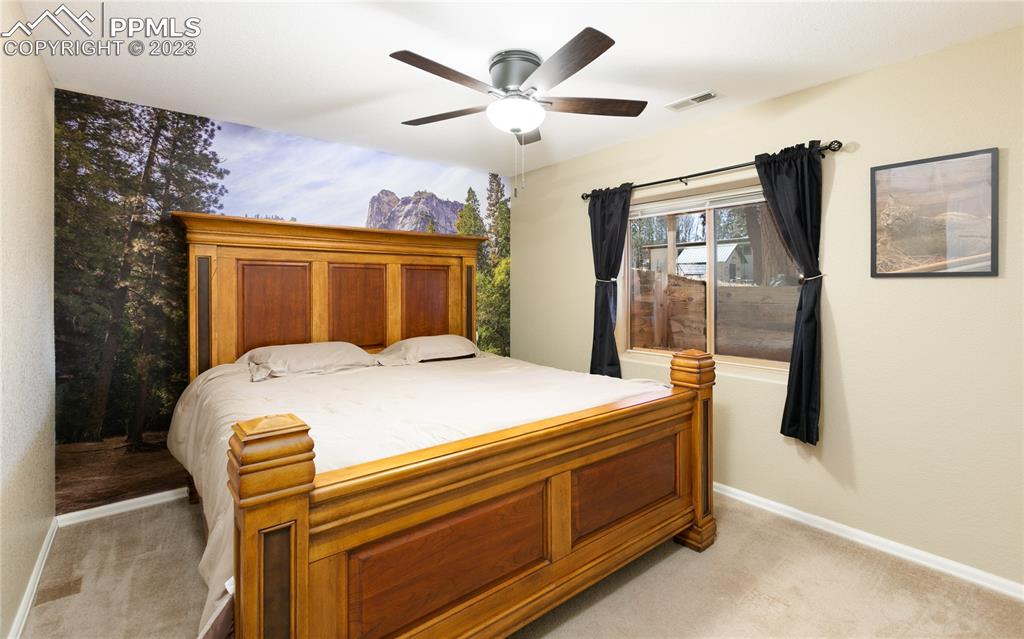 840 West Kelly Road Woodland Park, CO 80863 - Photo 29 of 37 a bedroom with a bed and a chandelier