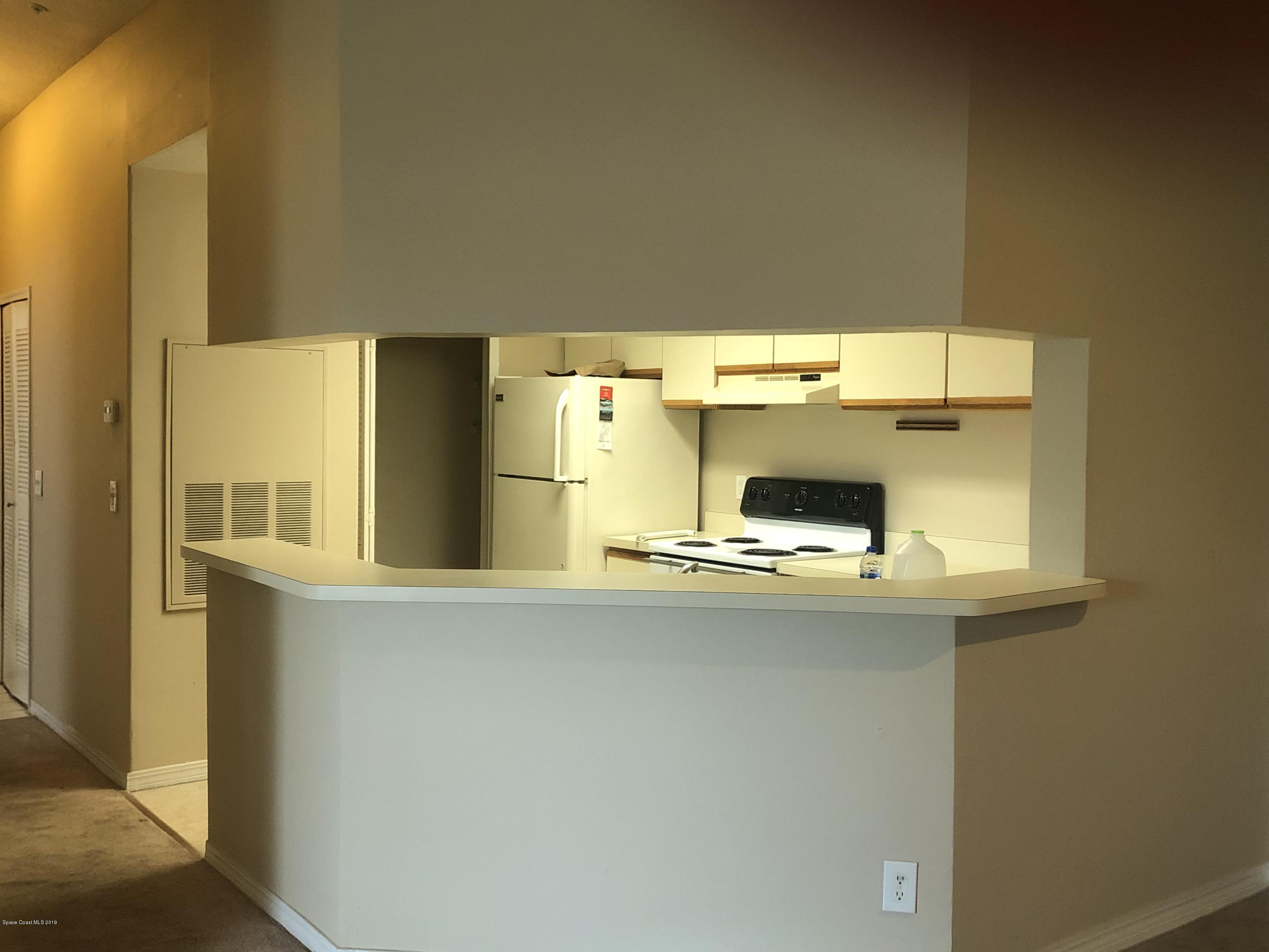 7667 North Wickham Road, Unit 915 Melbourne, FL 32940 - Photo 3 of 12 a kitchen with a sink and a refrigerator