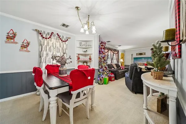 a view of a dining room with furniture and a chandelier