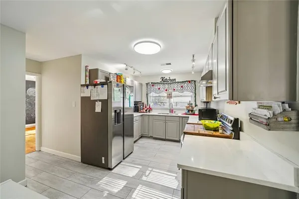 a kitchen with stainless steel appliances a refrigerator and a cabinets