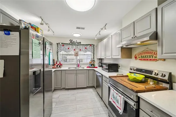a kitchen with stainless steel appliances a sink window and cabinets