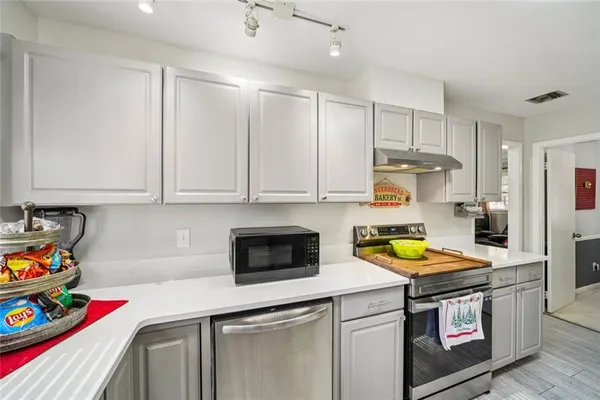 a kitchen with stainless steel appliances granite countertop a sink a stove and a cabinets