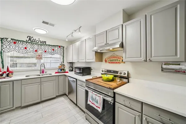 a kitchen with a sink a stove and cabinets