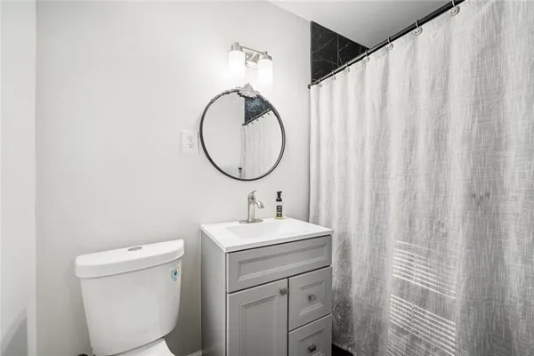 a bathroom with a sink toilet and a mirror