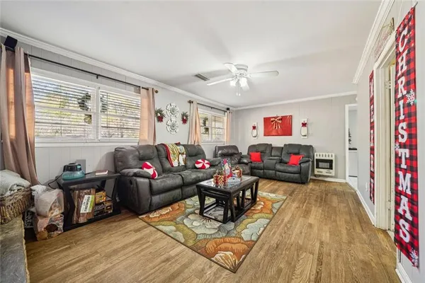 a living room with furniture and a wooden floor