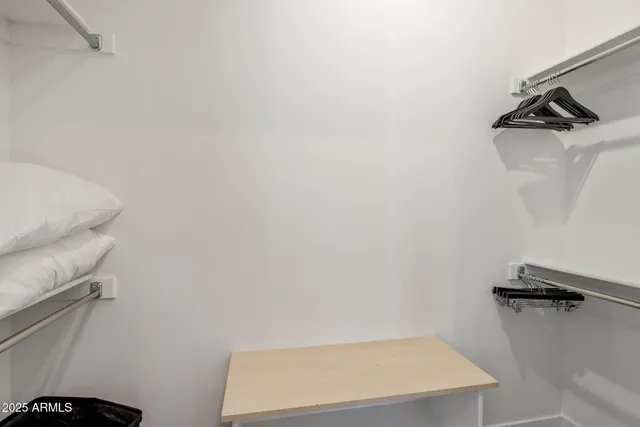 a bedroom with a bed and a flat tv screen on wall