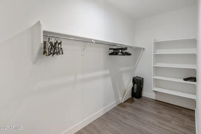 a kitchen with stainless steel appliances granite countertop a refrigerator a oven a sink dishwasher and a dining table with wooden floor