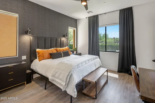 a bedroom with a bed and a flat tv screen on dresser