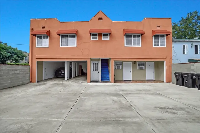 a living room filled with furniture and kitchen view