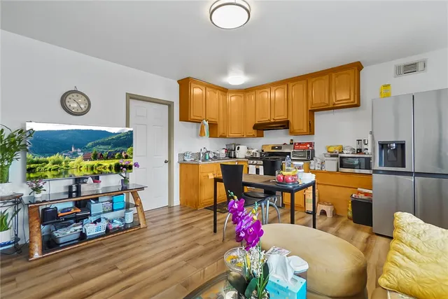 a kitchen with stainless steel appliances granite countertop a sink a stove and wooden cabinets