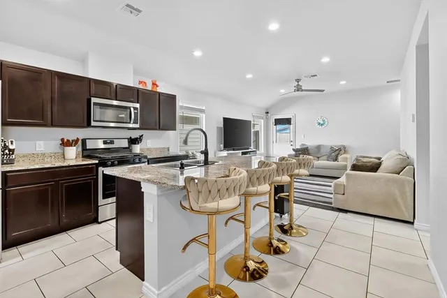 a living room with furniture a flat screen tv and kitchen view