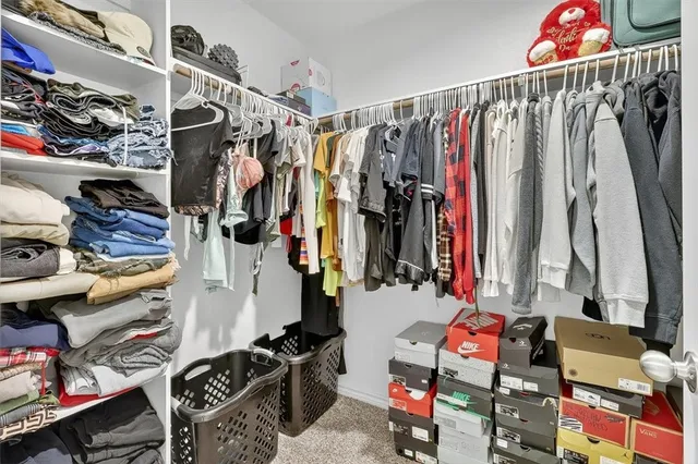 a view of walk in closet with clothes