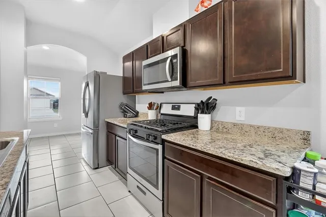 a kitchen with stainless steel appliances granite countertop a stove microwave and sink