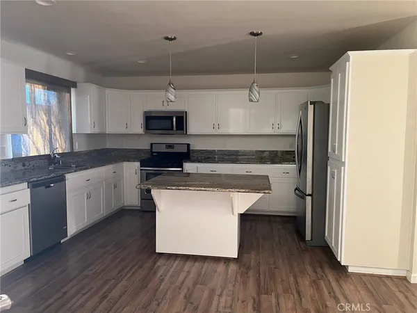 a kitchen with kitchen island stainless steel appliances a stove a sink and a refrigerator