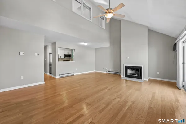 a view of empty room with wooden floor and fireplace