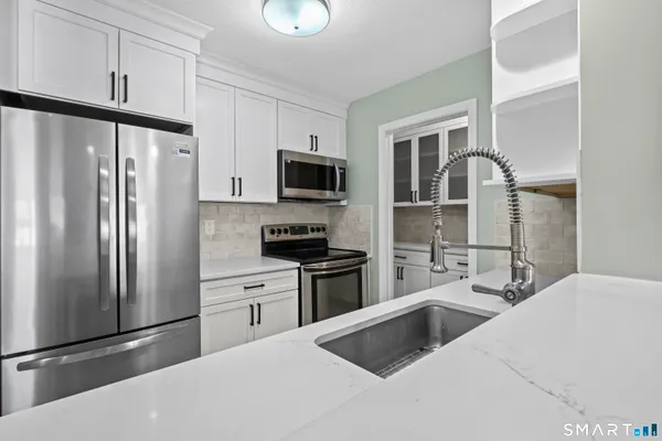 a kitchen with stainless steel appliances a refrigerator sink and microwave