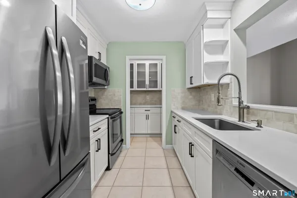 a kitchen with white cabinets and stainless steel appliances