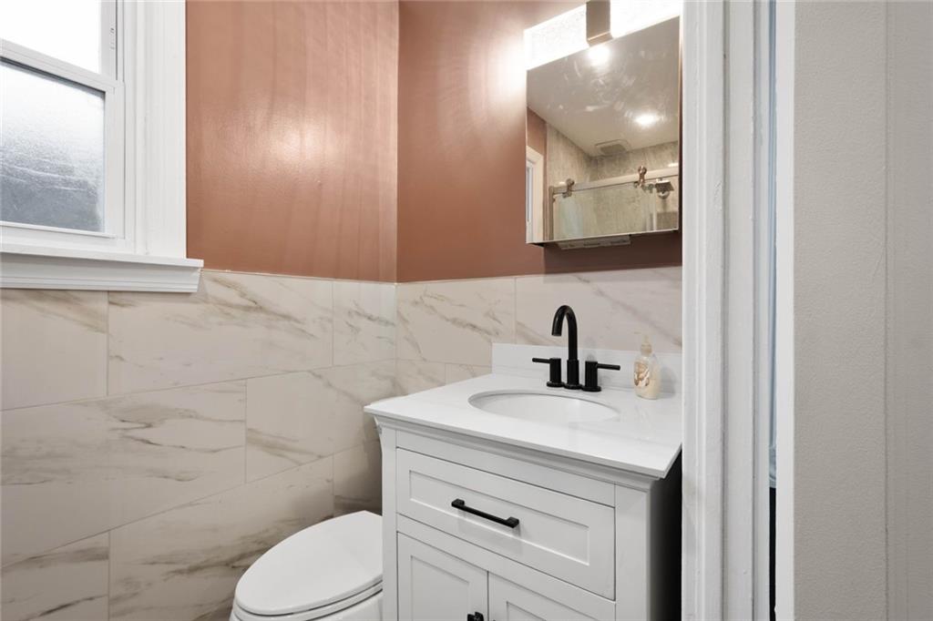 7129 Michigan Street Pittsburgh, PA 15218 - Photo 13 of 25 a bathroom with a sink vanity mirror and toilet