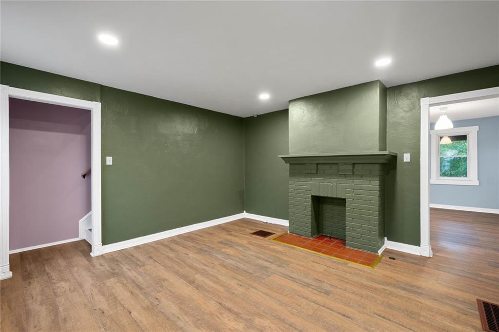 7129 Michigan Street Pittsburgh, PA 15218 - Photo 2 of 25 an empty room with wooden floor and fireplace