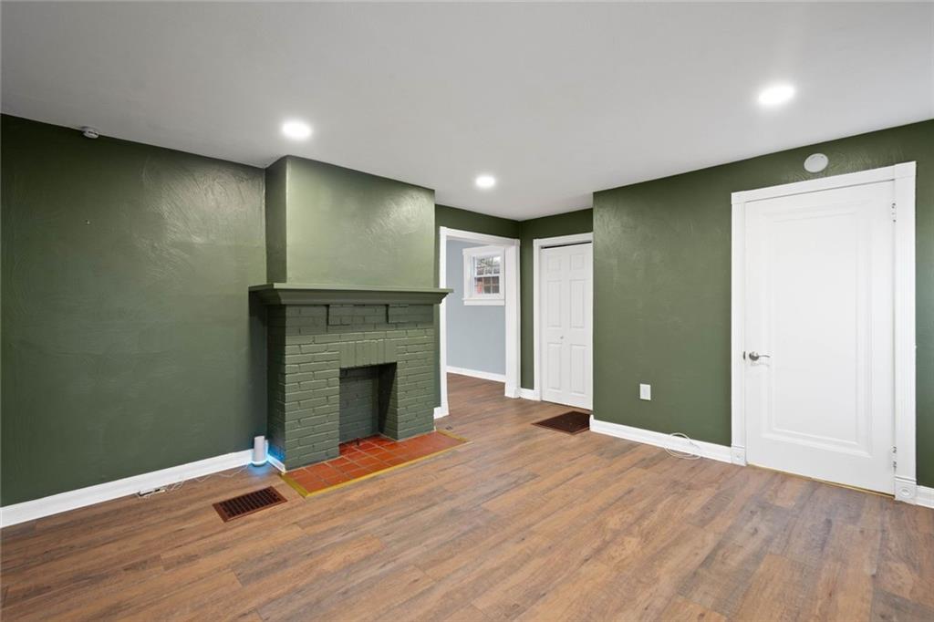 7129 Michigan Street Pittsburgh, PA 15218 - Photo 4 of 25 an empty room with wooden floor and fireplace