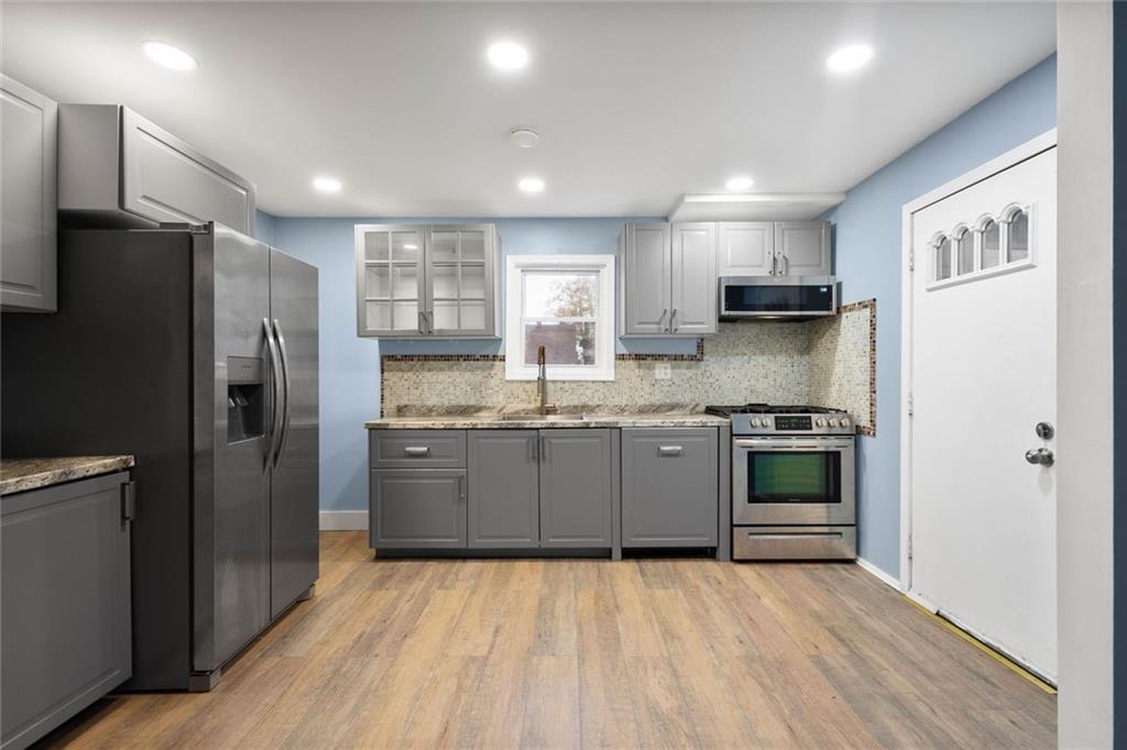 7129 Michigan Street Pittsburgh, PA 15218 - Photo 7 of 25 a kitchen with stainless steel appliances granite countertop a refrigerator and a stove top oven