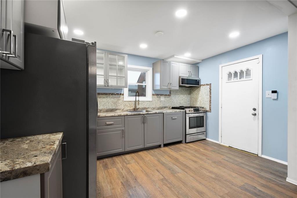 7129 Michigan Street Pittsburgh, PA 15218 - Photo 10 of 25 a kitchen with a refrigerator and a stove top oven