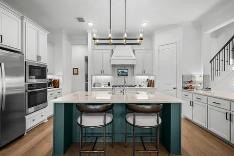 a kitchen with kitchen island granite countertop a sink and stainless steel appliances