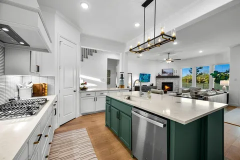 a kitchen with lots of counter top space a sink stainless steel appliances and cabinets