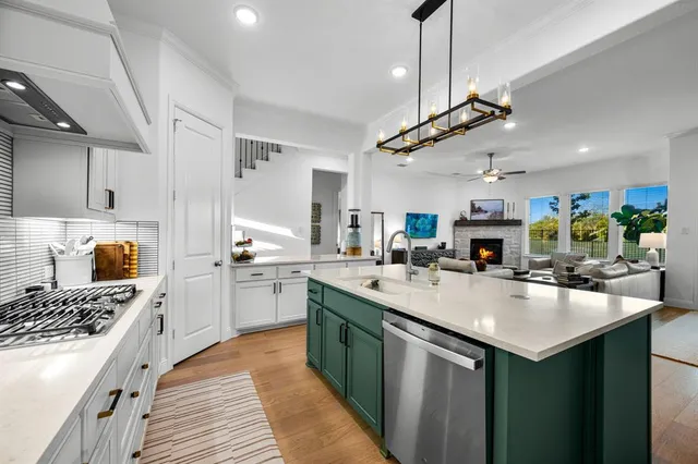 a kitchen with lots of counter top space a sink stainless steel appliances and cabinets
