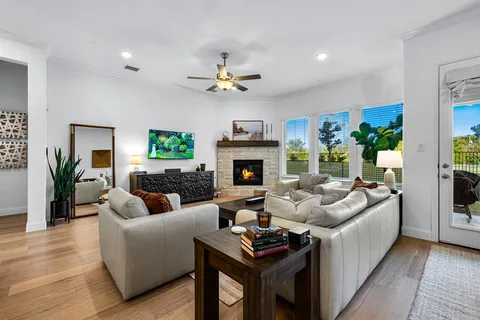 a living room with furniture a fireplace and a ceiling fan