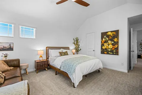 a bedroom with bed couch and window