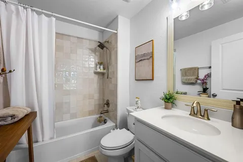 a living room with a bed furniture and painting on the wall