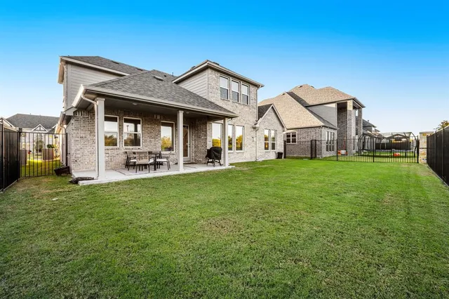 a balcony with table and chairs and potted plants